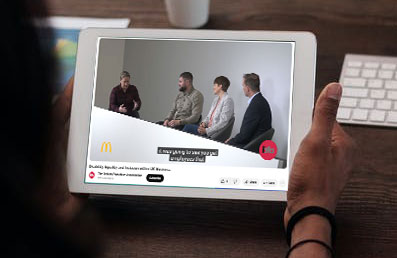 A person holding tablet viewing a live stream with 4 presenters.